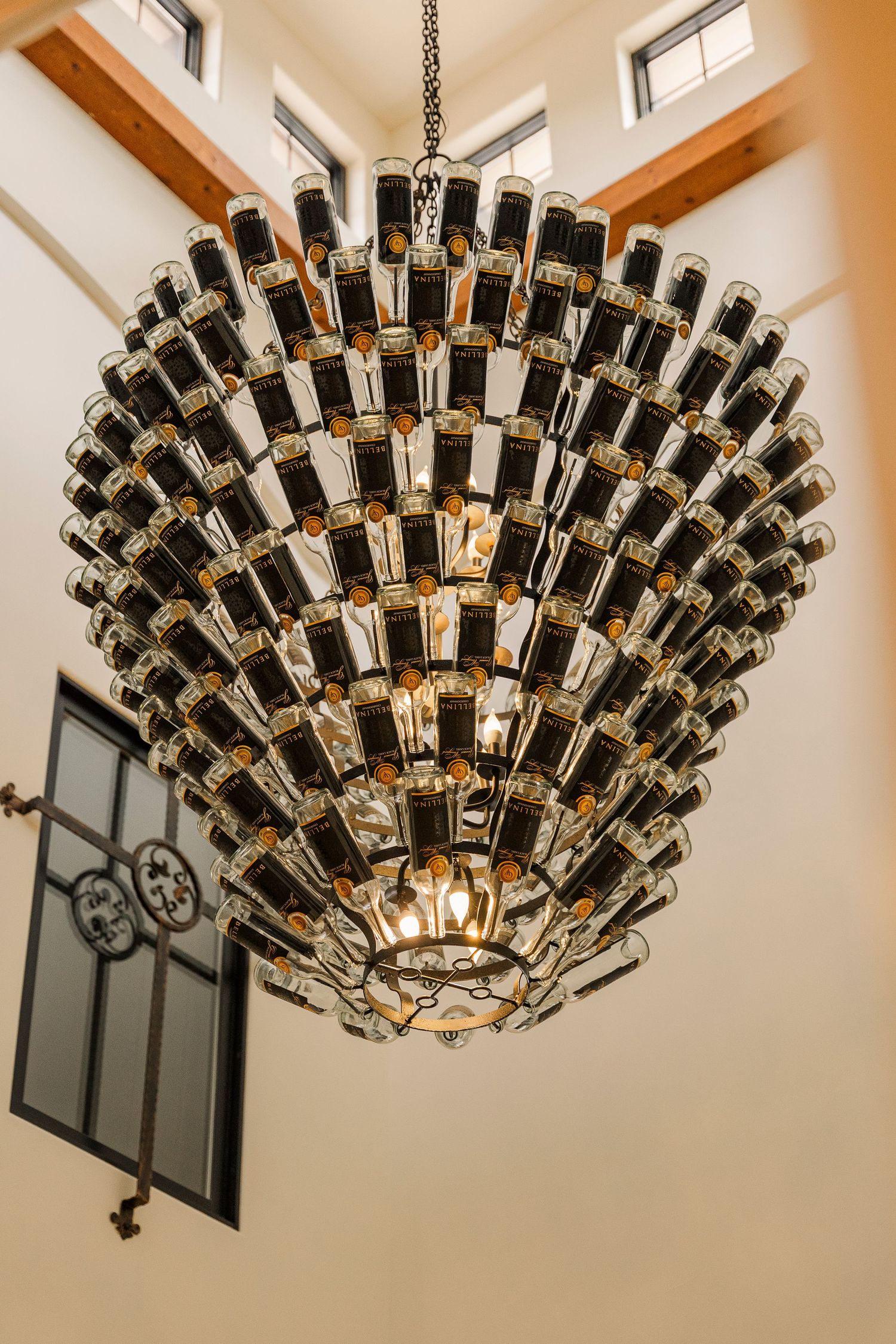 Stunning chandelier made of wine bottles hanging at elegant Gervasi vineyard wedding venue.