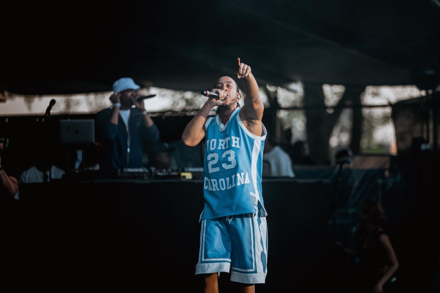 Performer in North Carolina #23 jersey singing on stage.