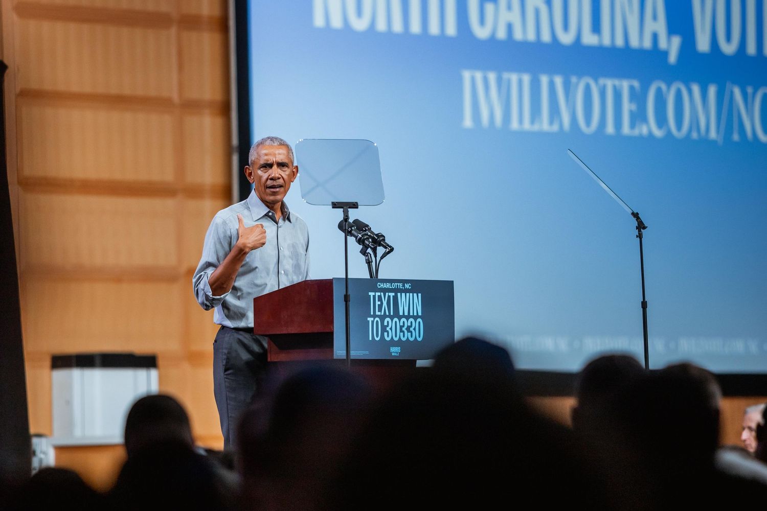 Man speaking at a North Carolina voter rally podium with iWillVote.com signage.