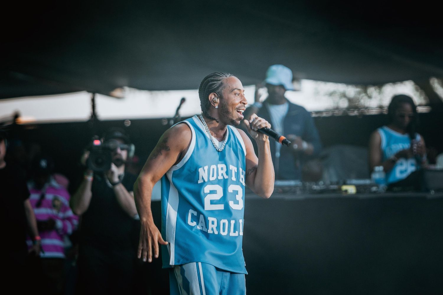 Singer with braids performing in North Carolina #23 jersey on stage.
