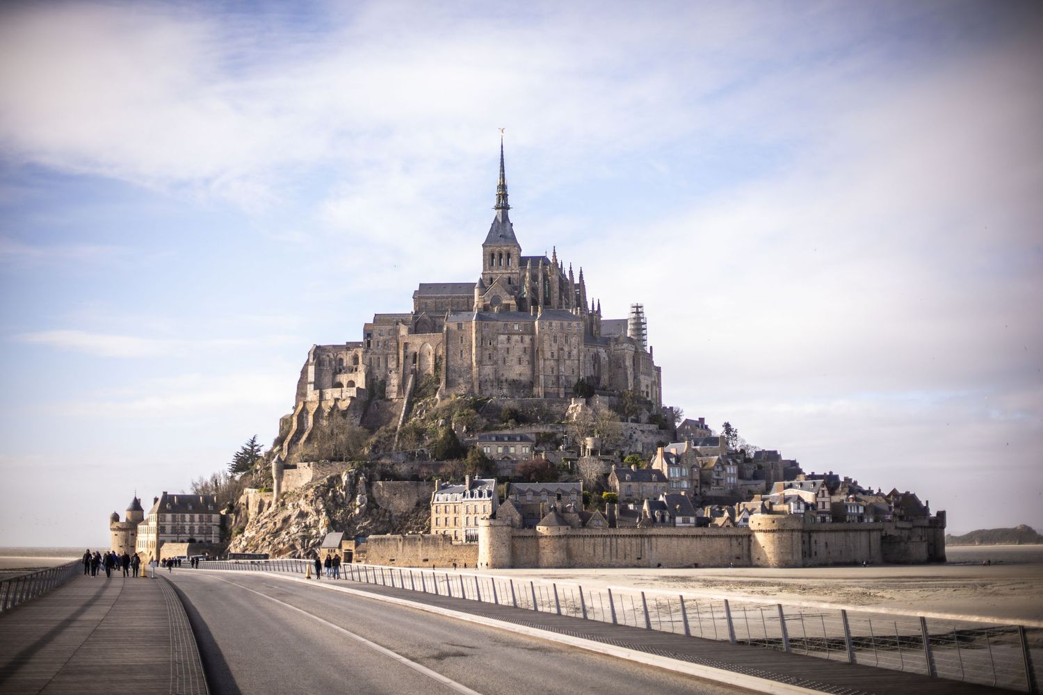 Aerial view of Mont Saint-Michel medieval abbey rising dramatically from tidal flats in Normandy, France.