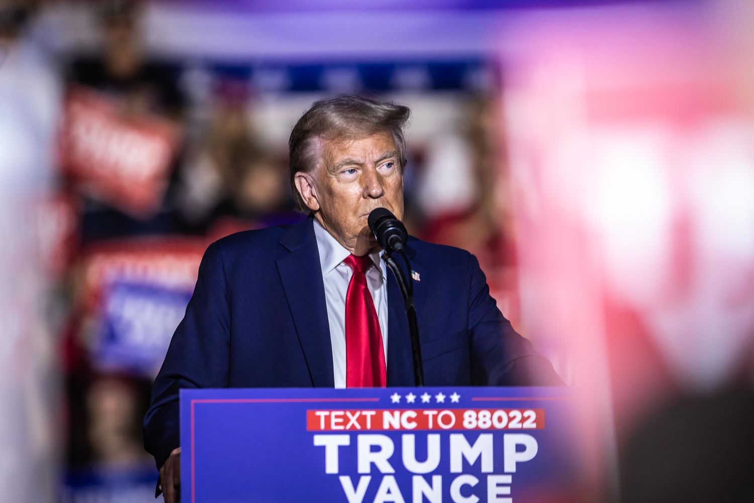 Donald Trump stands solemnly at the Trump Vance podium during a 2024 campaign rally in North Carolina.