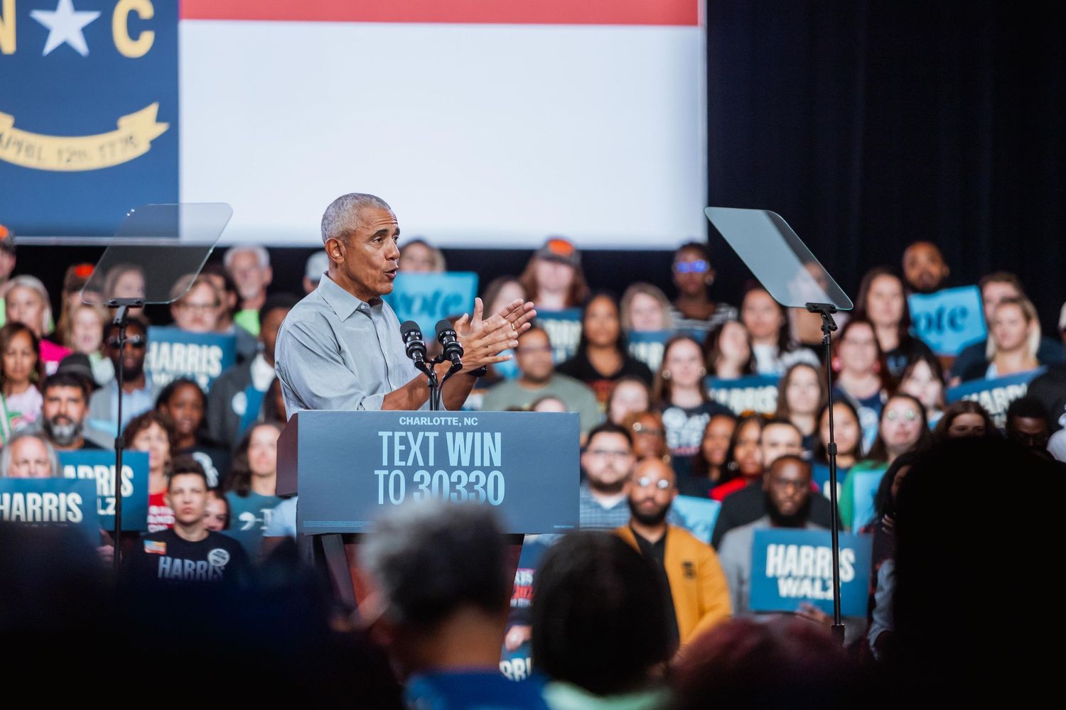 Speaker at a Harris-Walz campaign rally in North Carolina addressing a large crowd.