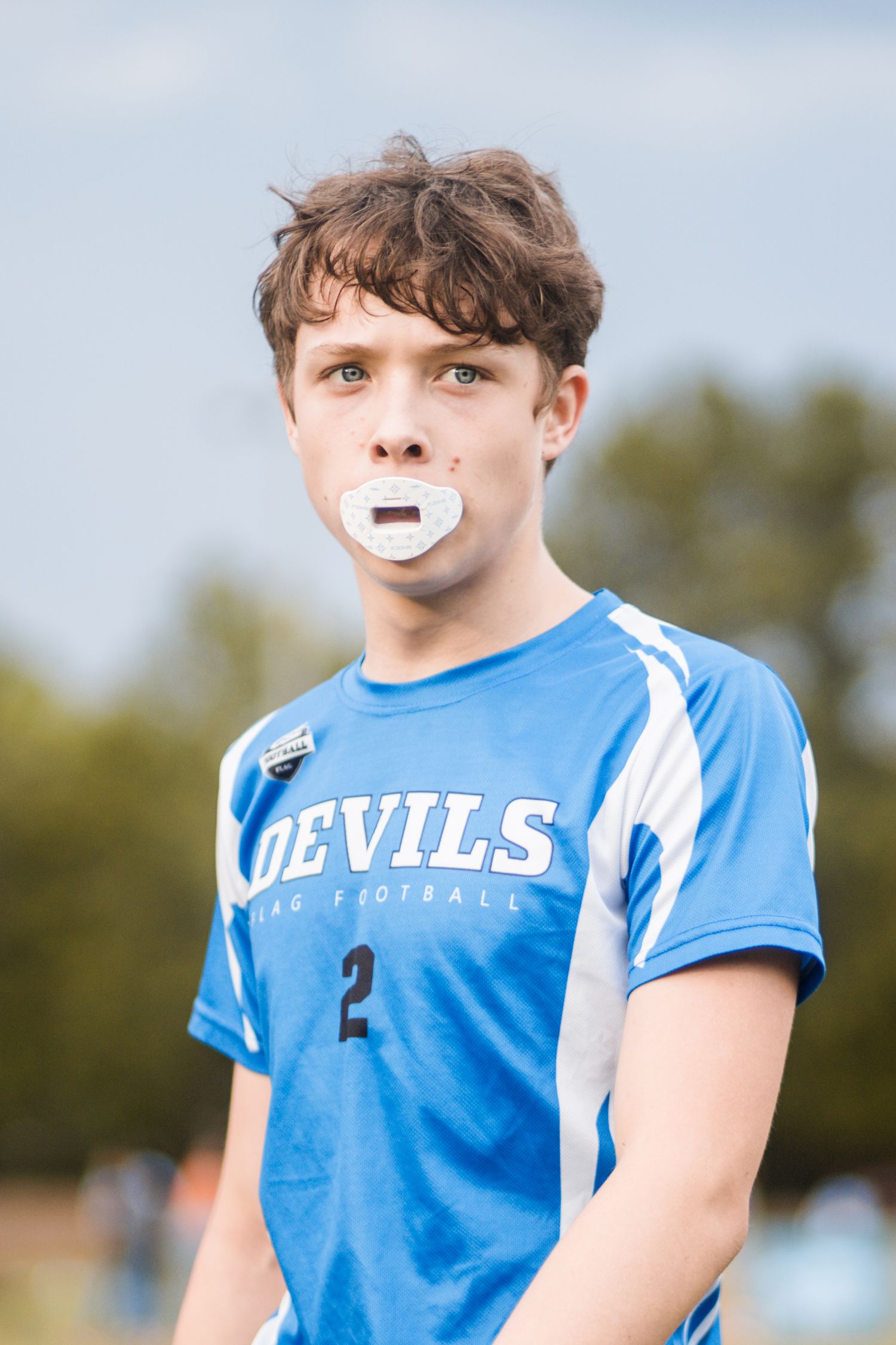 Youth football player number 2 in blue Devils jersey wearing a white mouthguard.