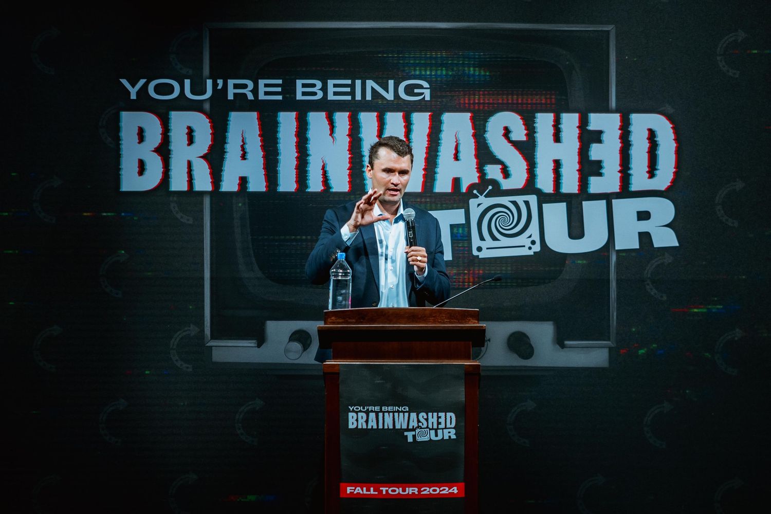 Speaker holding an award at the You Are Being Brainwashed Tour fall 2024 event.