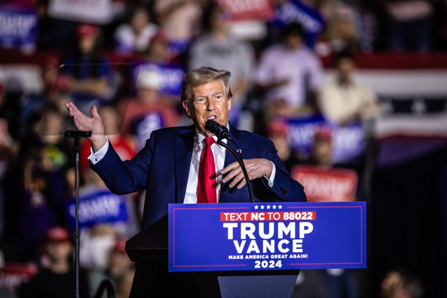 Donald Trump gestures with open arms at a Trump Vance 2024 Make America Great Again campaign rally in NC.