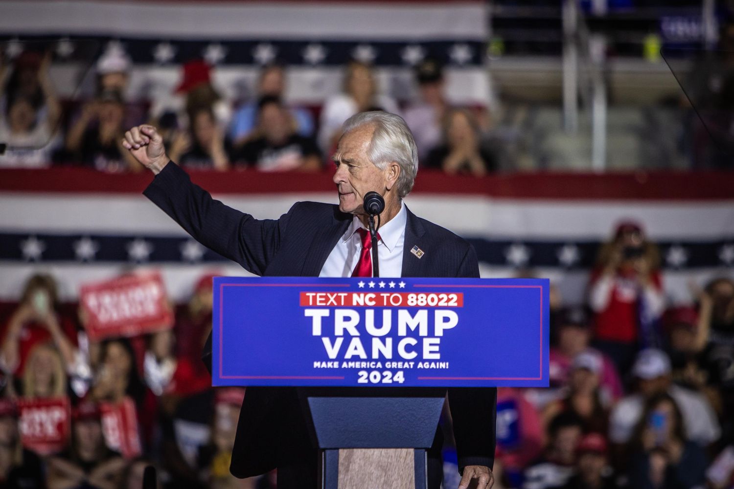 Man raises fist while speaking at Trump Vance 2024 presidential campaign rally.