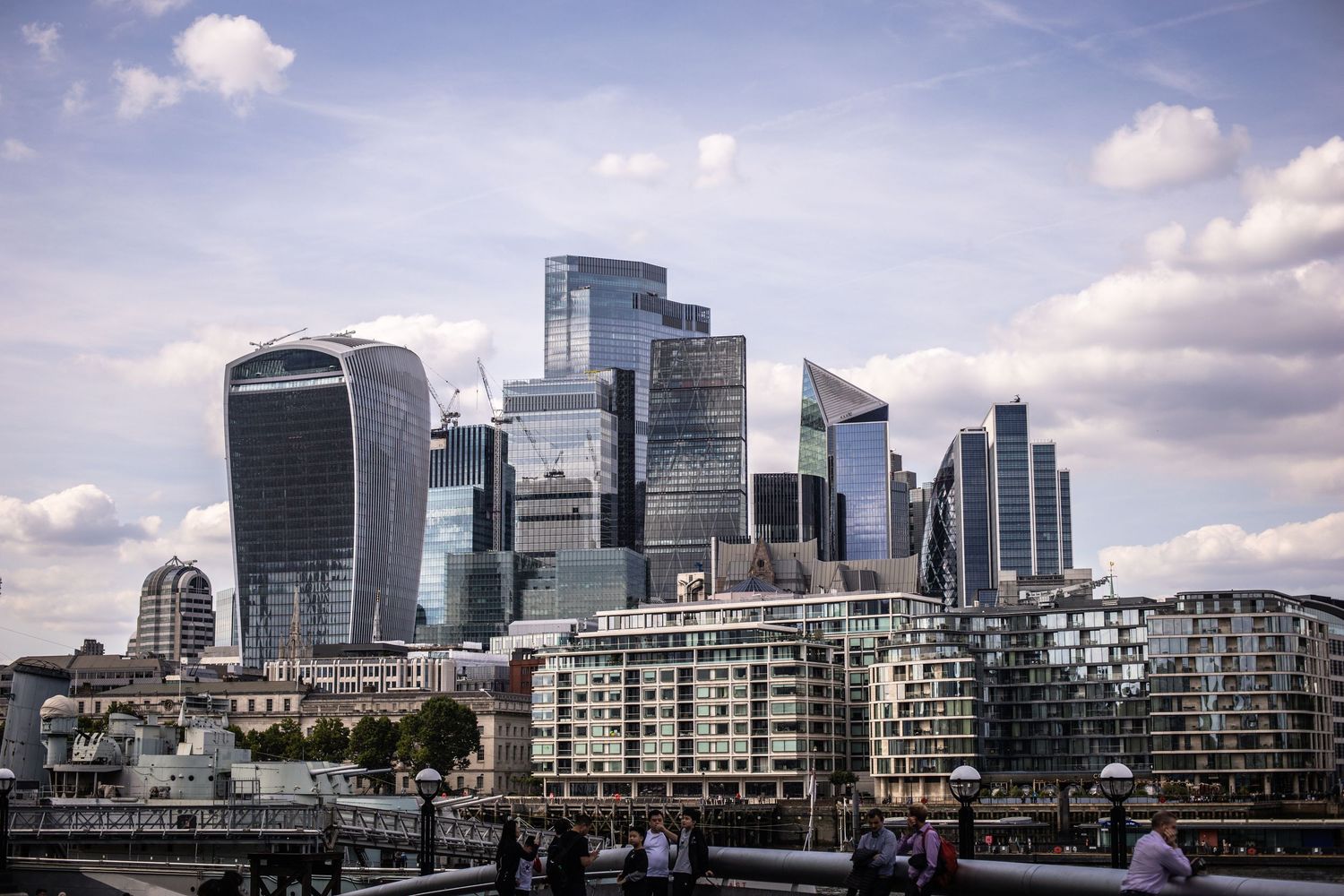 City of London skyline featuring modern skyscrapers including the Walkie-Talkie building under cloudy sky.