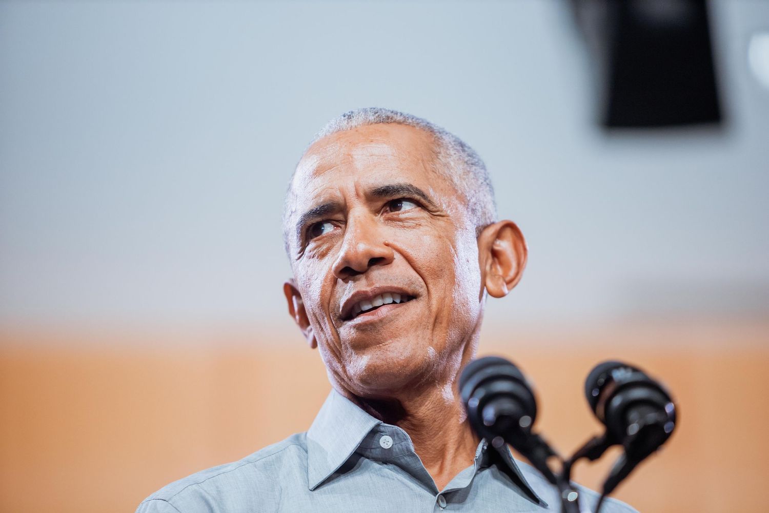 Close-up of a man with gray hair speaking passionately at a campaign event.