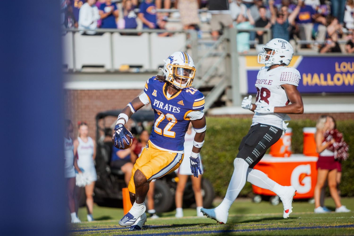 ECU Pirates football player #22 defends against opponent during a Halloween homecoming game at Dowdy-Ficklen Stadium.