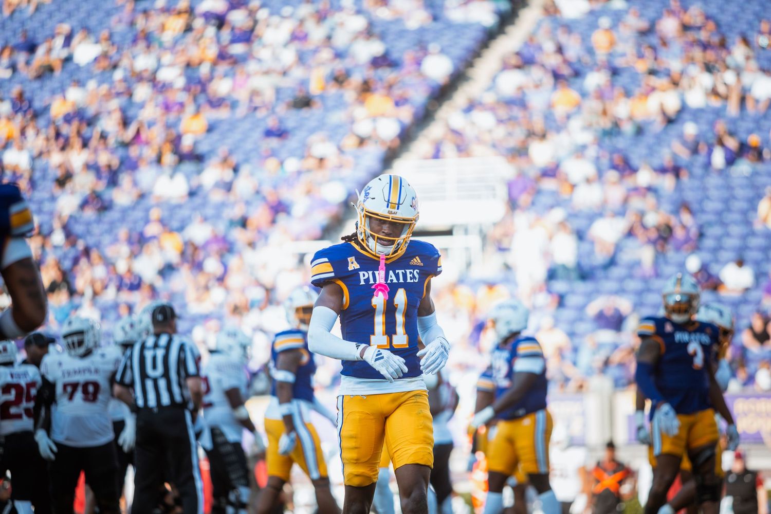 ECU Pirates football player #11 stands on the field during a game at Dowdy-Ficklen Stadium.