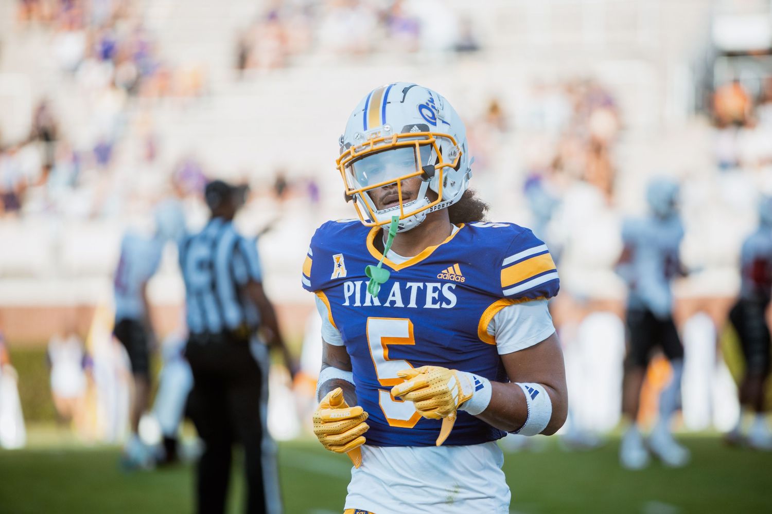 ECU Pirates football player #5 gives a thumbs down gesture on the field during a game.