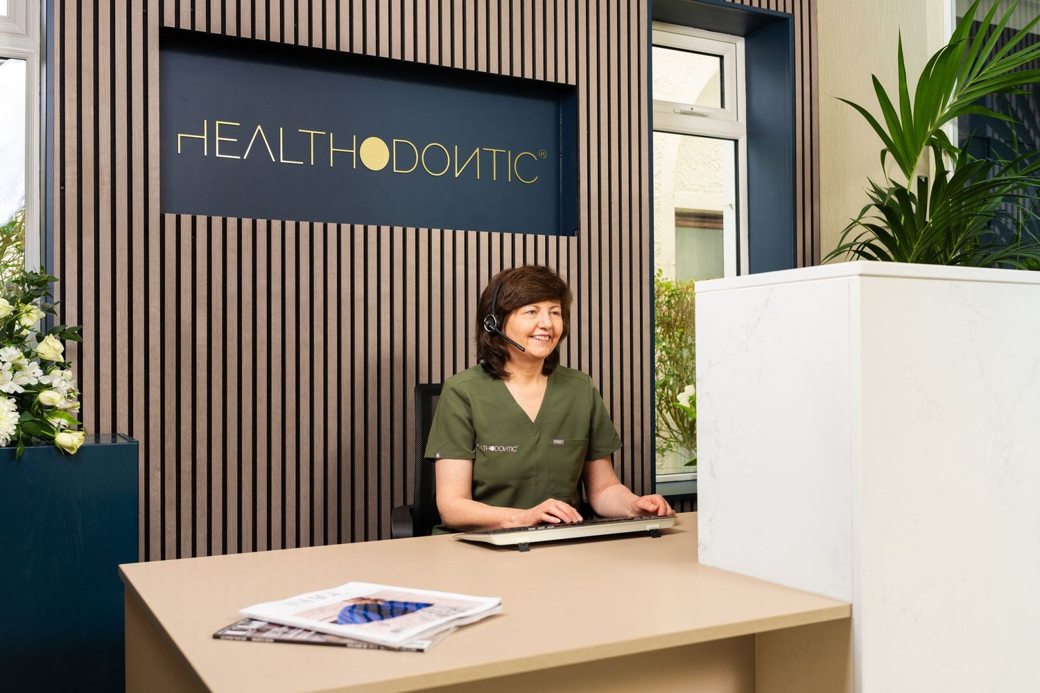 Dental receptionist taking calls at front desk