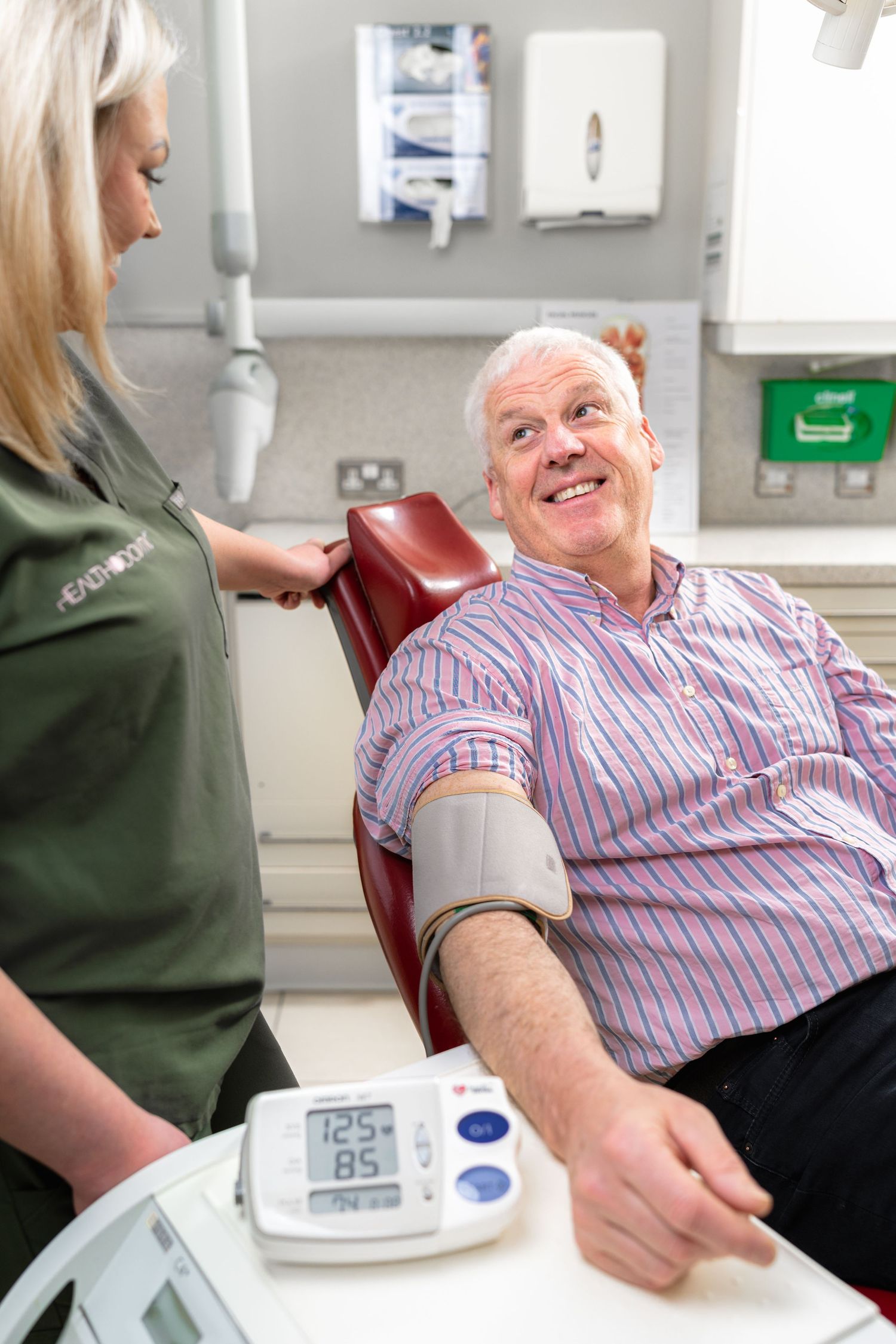 Dental surgery with patient getting blood pressure test with dental nurse