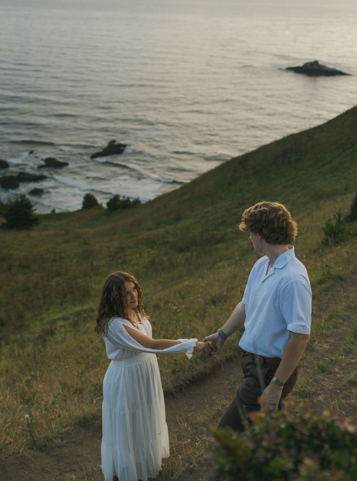 Couple embracing on the cliffs overlooking the Pacific Ocean.