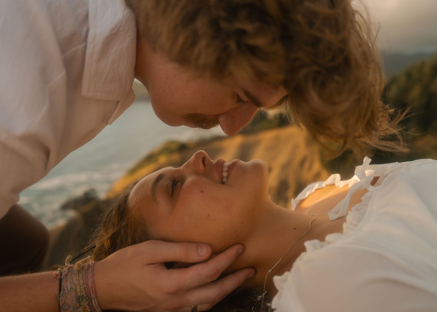 Couple embracing on the cliffs overlooking the Pacific Ocean.