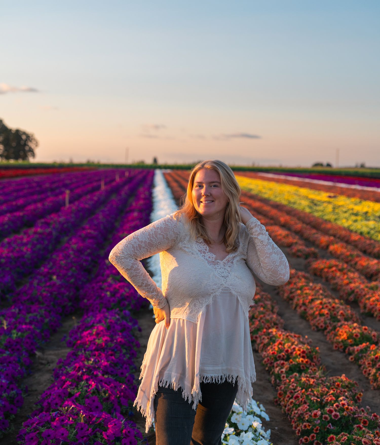 Portrait of photographer Amber Andrews standing in a colorful Oregon flower field at sunset.