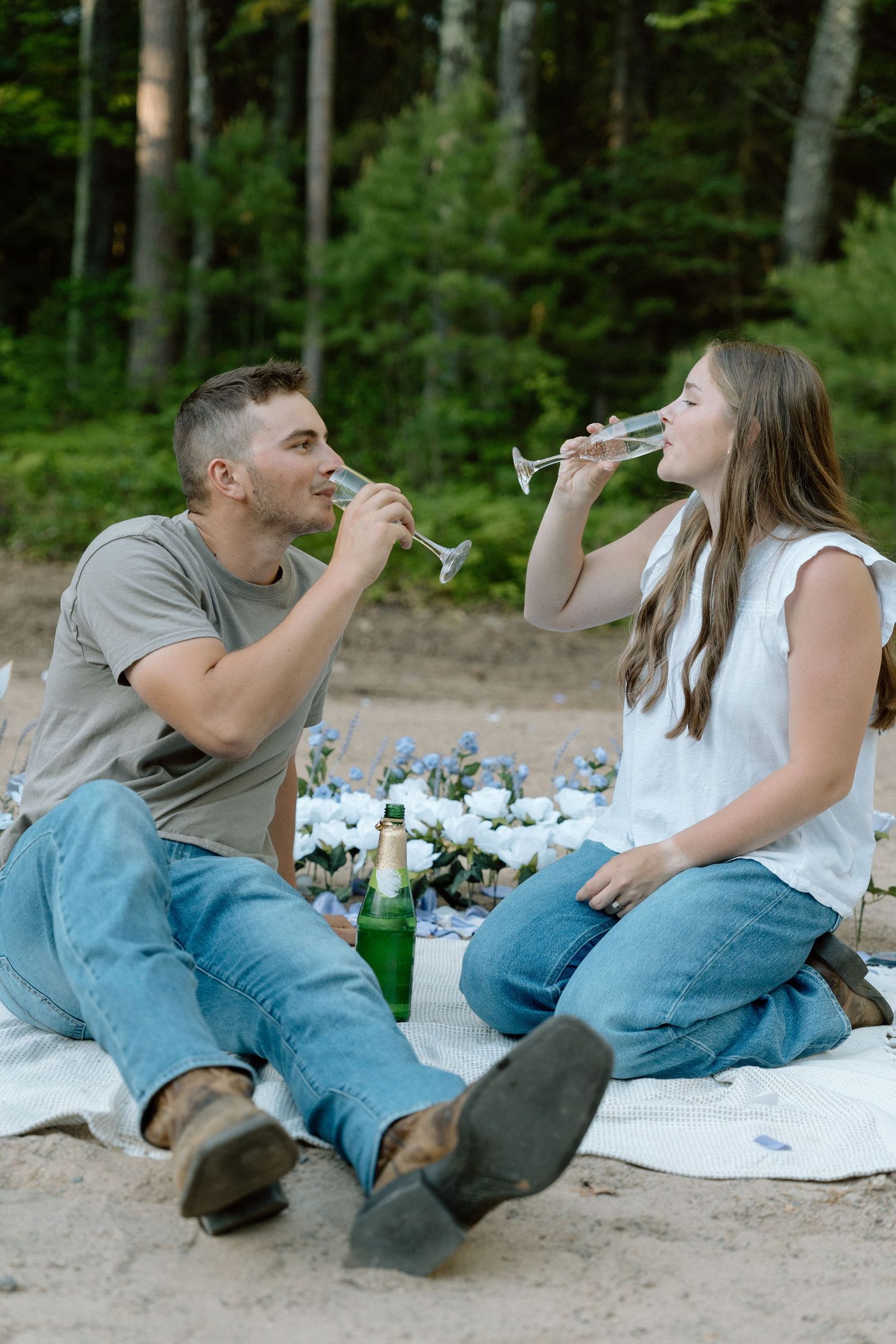proposal celebration, cowboy boots, flowers, champagne, picnic