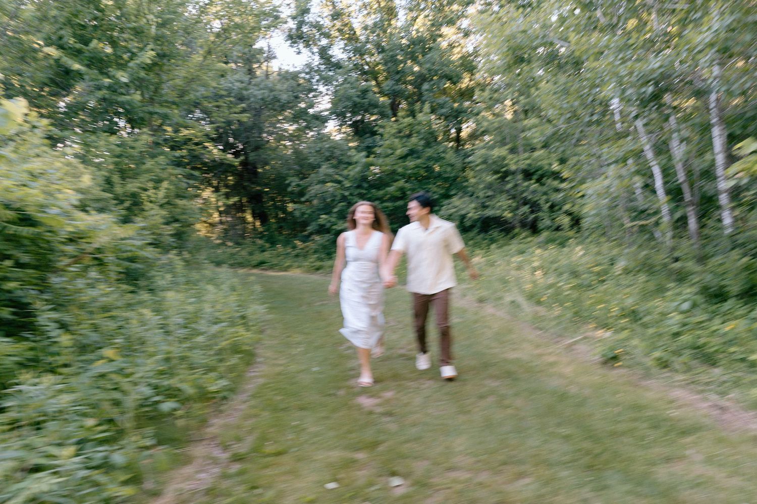 an engagement shoot in a field on a summer evening