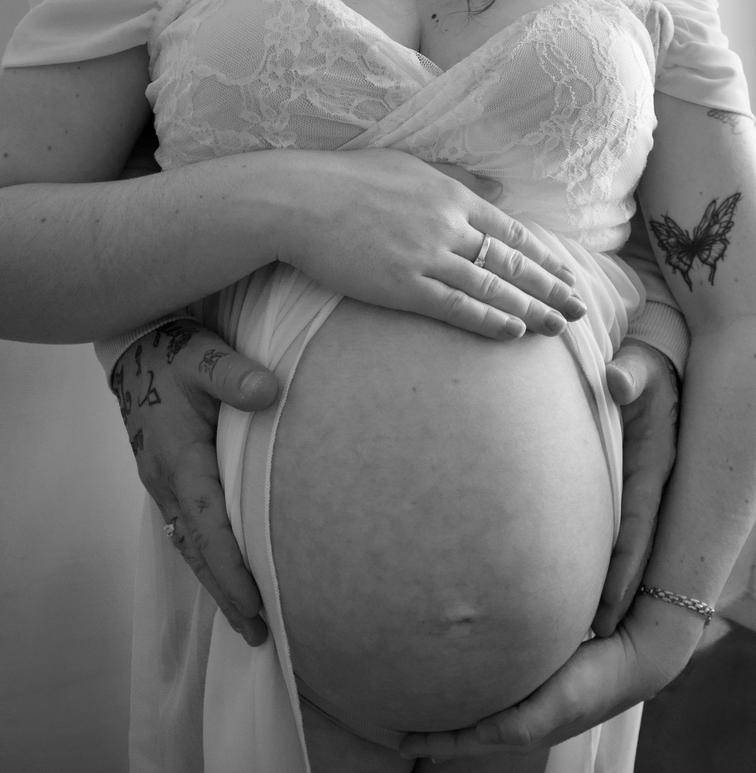 Détail du ventre arrondi d’une future maman en noir et blanc, photo maternité élégante.