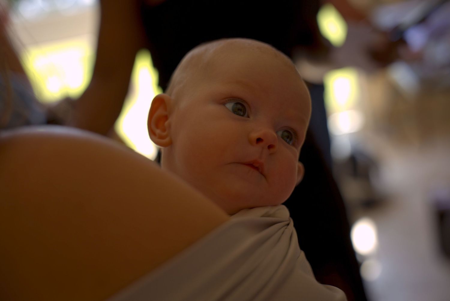 Bébé observant la réception dans une ambiance chaleureuse, photo naturelle pleine d’émotion et de douceur.