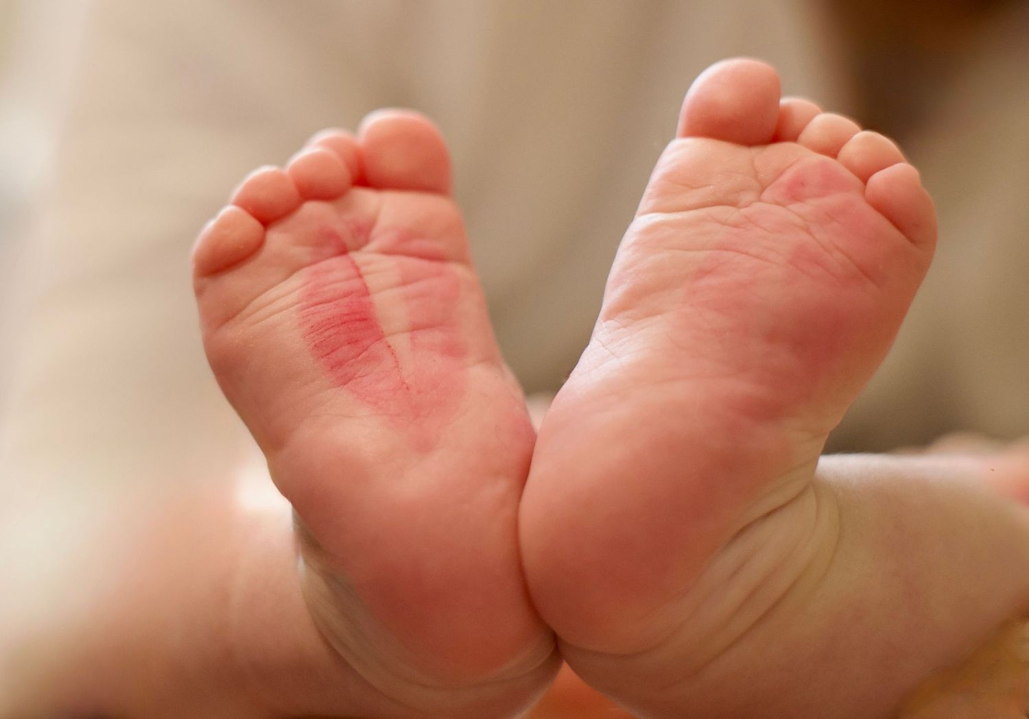 Gros plan sur les petits pieds d’un bébé, photo lifestyle douce et naturelle en intérieur.