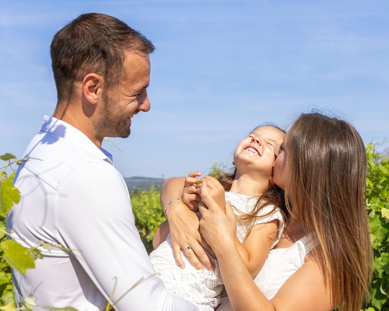 Parents et enfant souriants pendant une séance photo famille dans les vignes du Var
