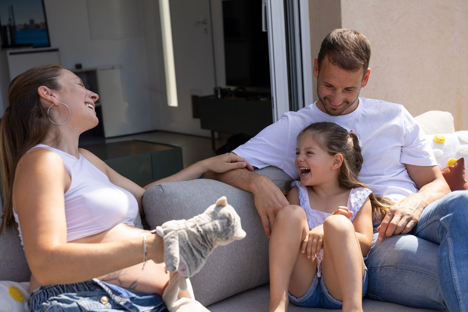 Famille partageant un moment complice pendant une séance photo grossesse à domicile