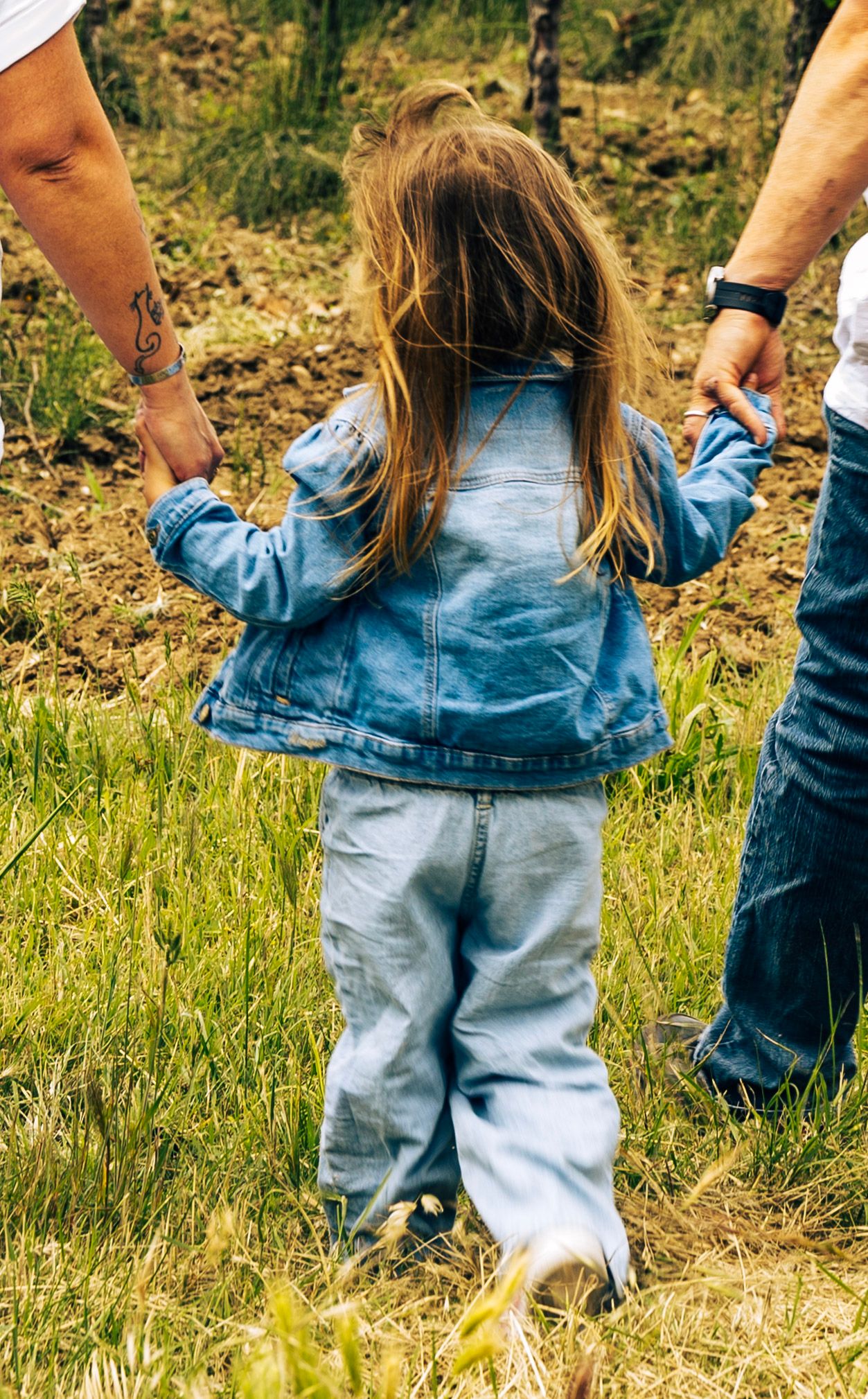 Petite fille marchant dans les vignes avec ses parents, instant de famille naturel en Provence.