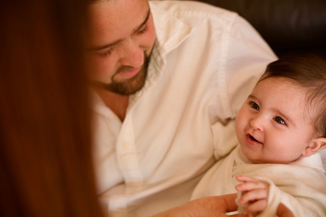 Bébé regardant son père avec tendresse, portrait famille lifestyle chaleureux en intérieur.