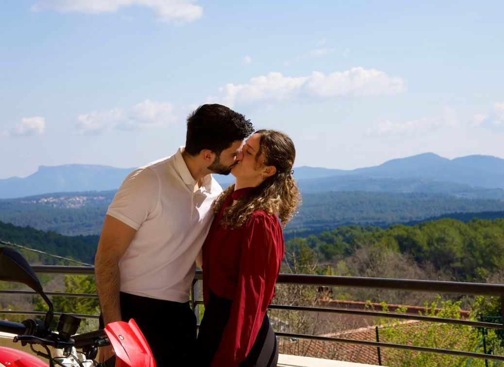 Couple s’embrassant avec vue panoramique, photo romantique en extérieur au coucher du soleil.