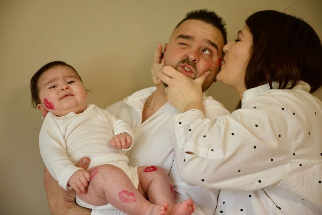Jeunes parents avec leur bébé lors d’une séance famille, ambiance douce et naturelle en intérieur.