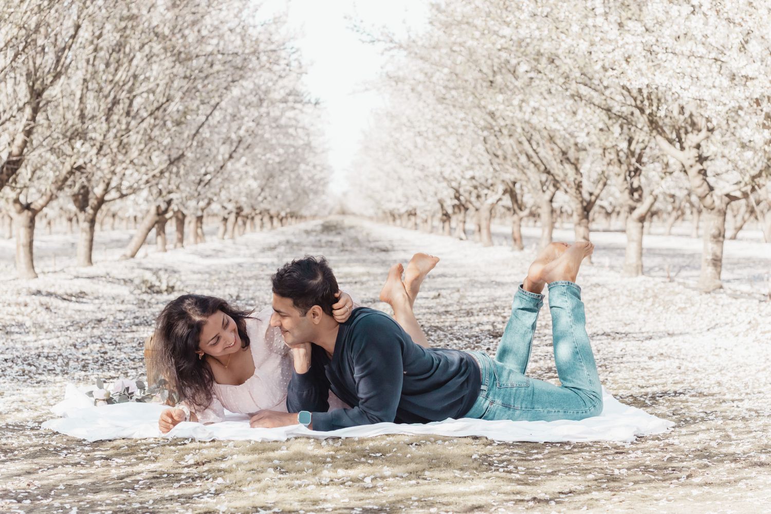A couple shares intimate moments in a snowy winter landscape during an outdoor photo session.