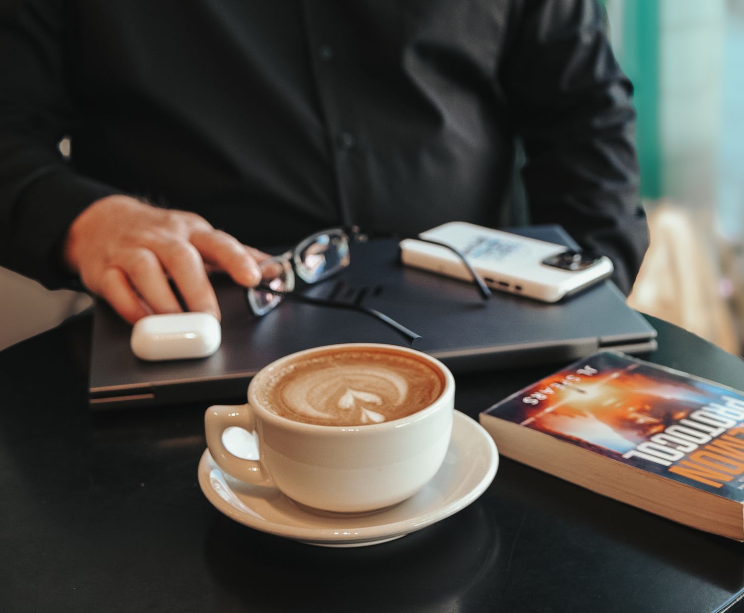 A series of latte art photos showing heart designs in coffee cups on dark wooden tables at a cafe.