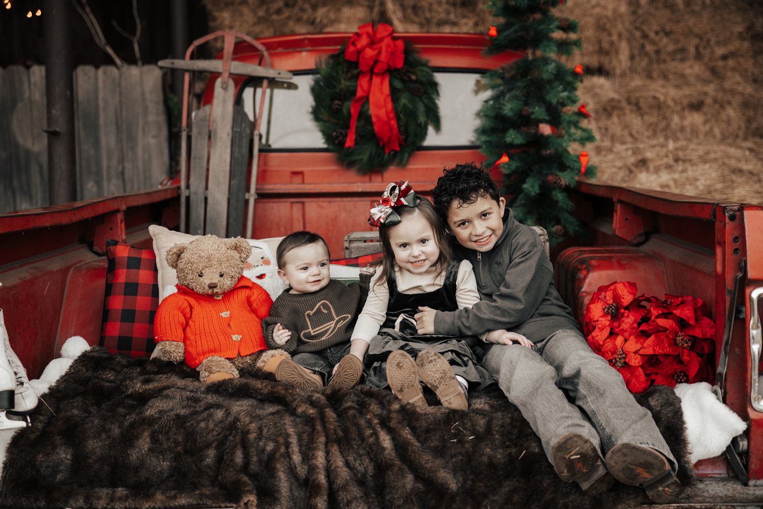 A group wearing cozy red plaid sits together on a rustic wooden porch decorated for the holidays.