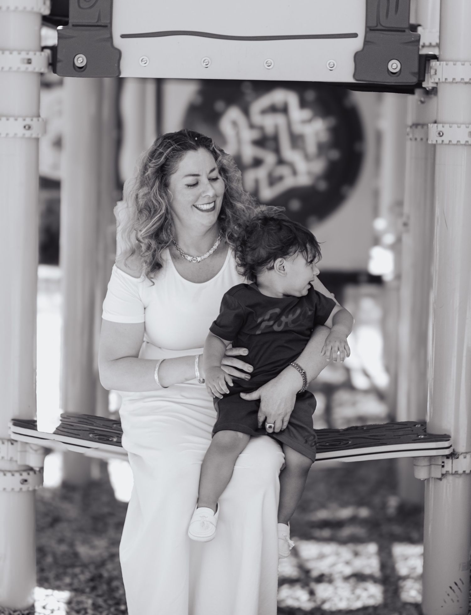 Black and white photo series showing tender moments between parent and child in a covered outdoor setting.