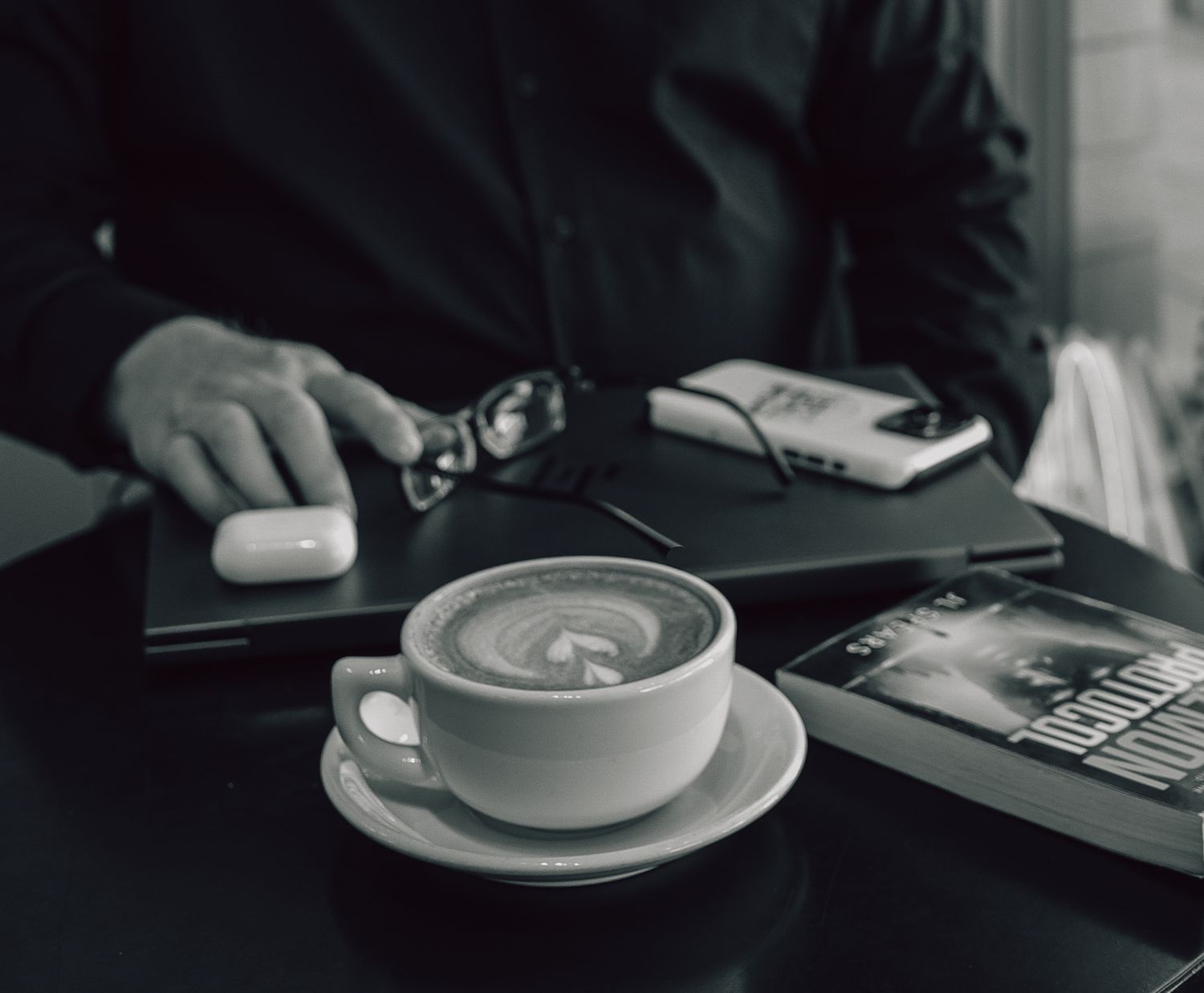A collection of artfully crafted latte art drinks shown in monochromatic black and white photography.