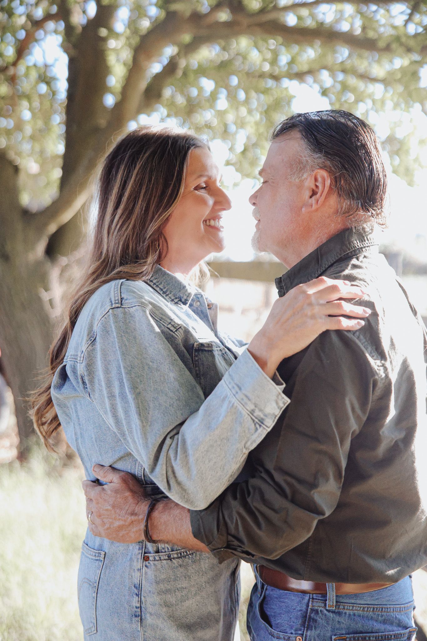 A couple shares intimate moments in a series of candid outdoor photos under trees with natural lighting.
