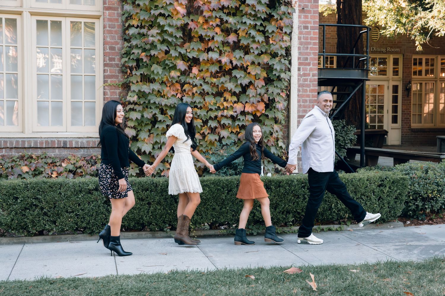 Family laughing during fall minis at UOP in Stockton, CA, captured candidly with warm foliage on October 17th.