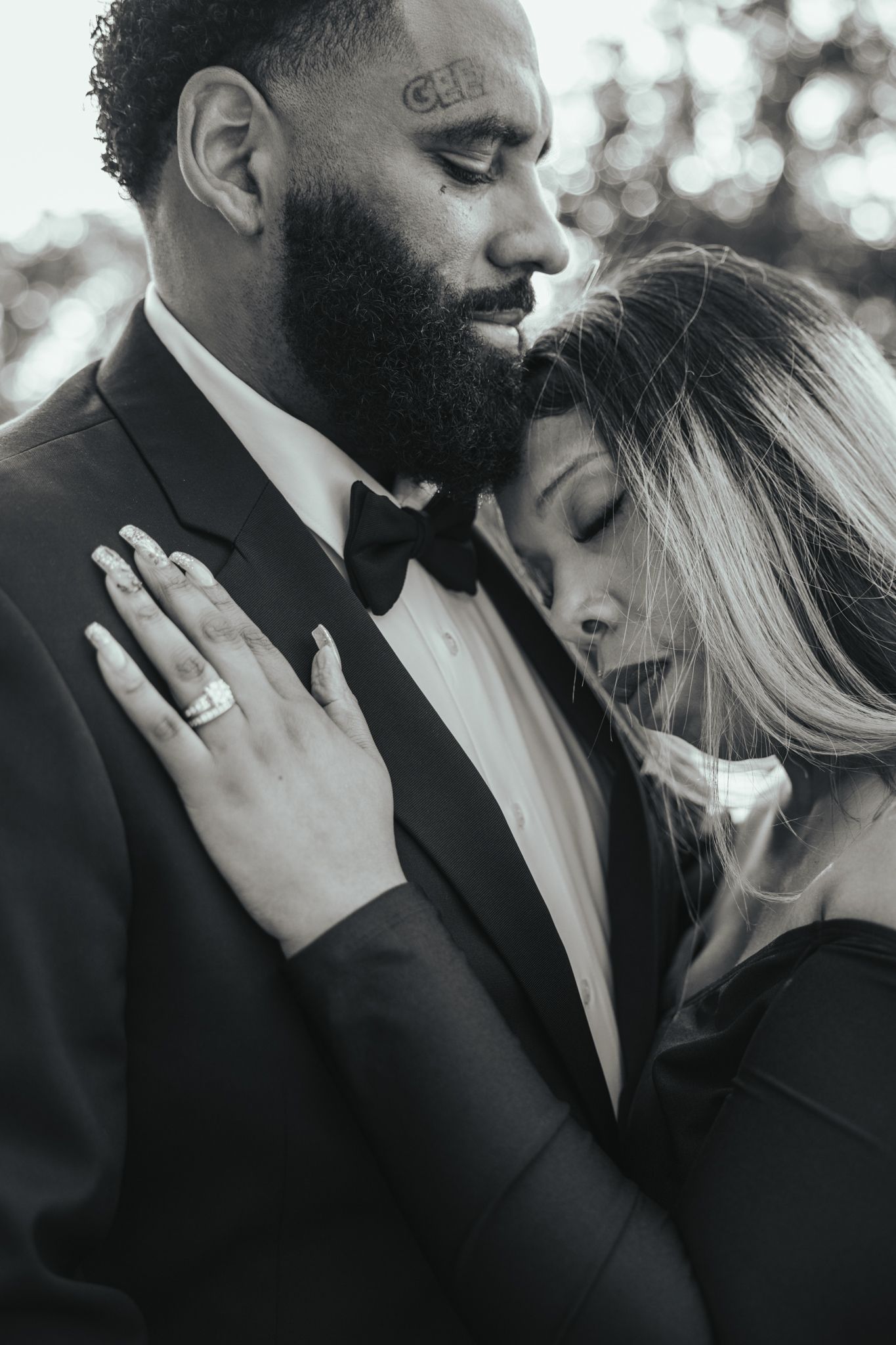 A romantic black and white photo series showing an intimate moment between a couple during their engagement session.