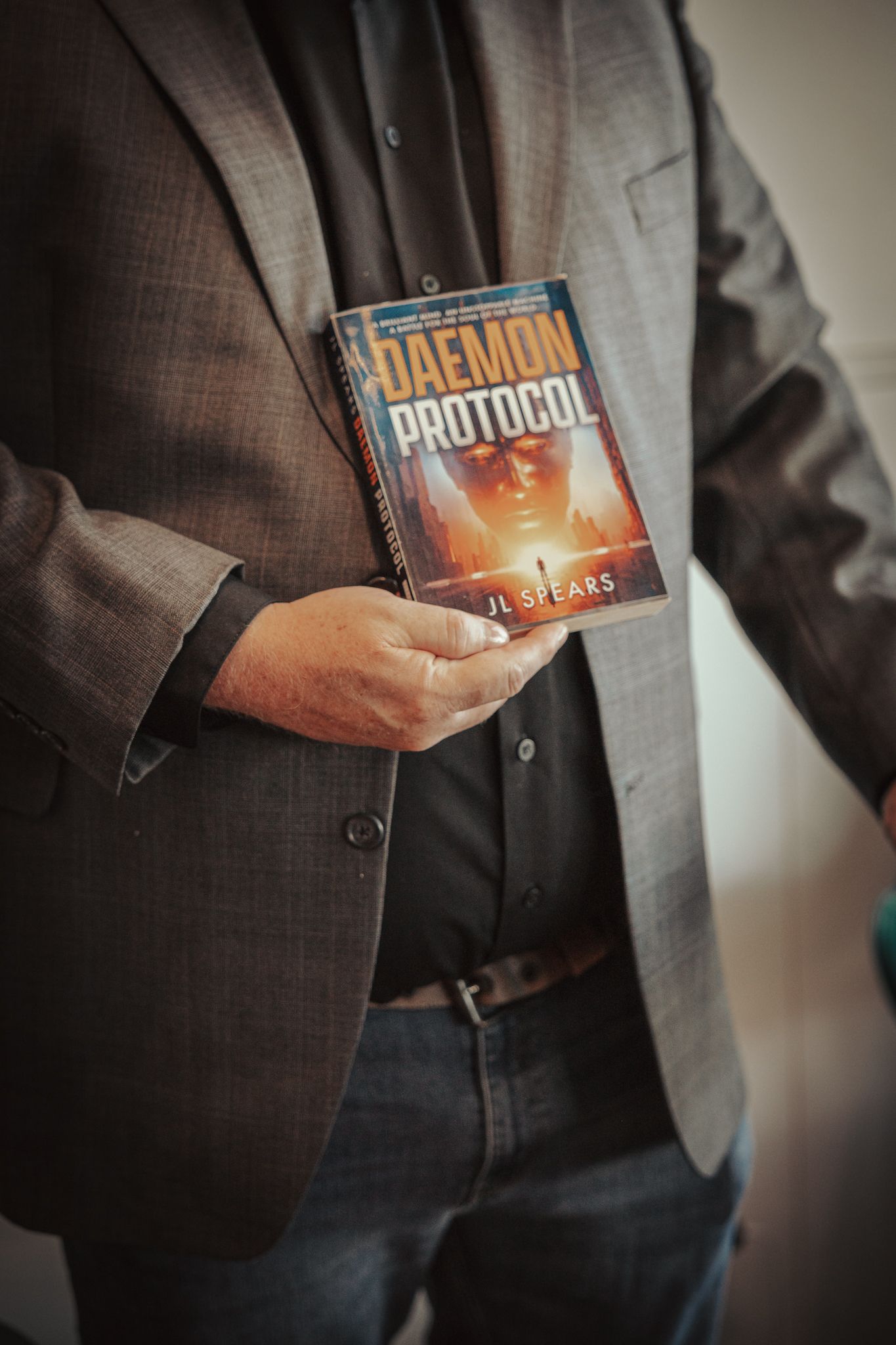 A person in a brown suit jacket holds computer software boxes in a sequence of promotional product shots.
