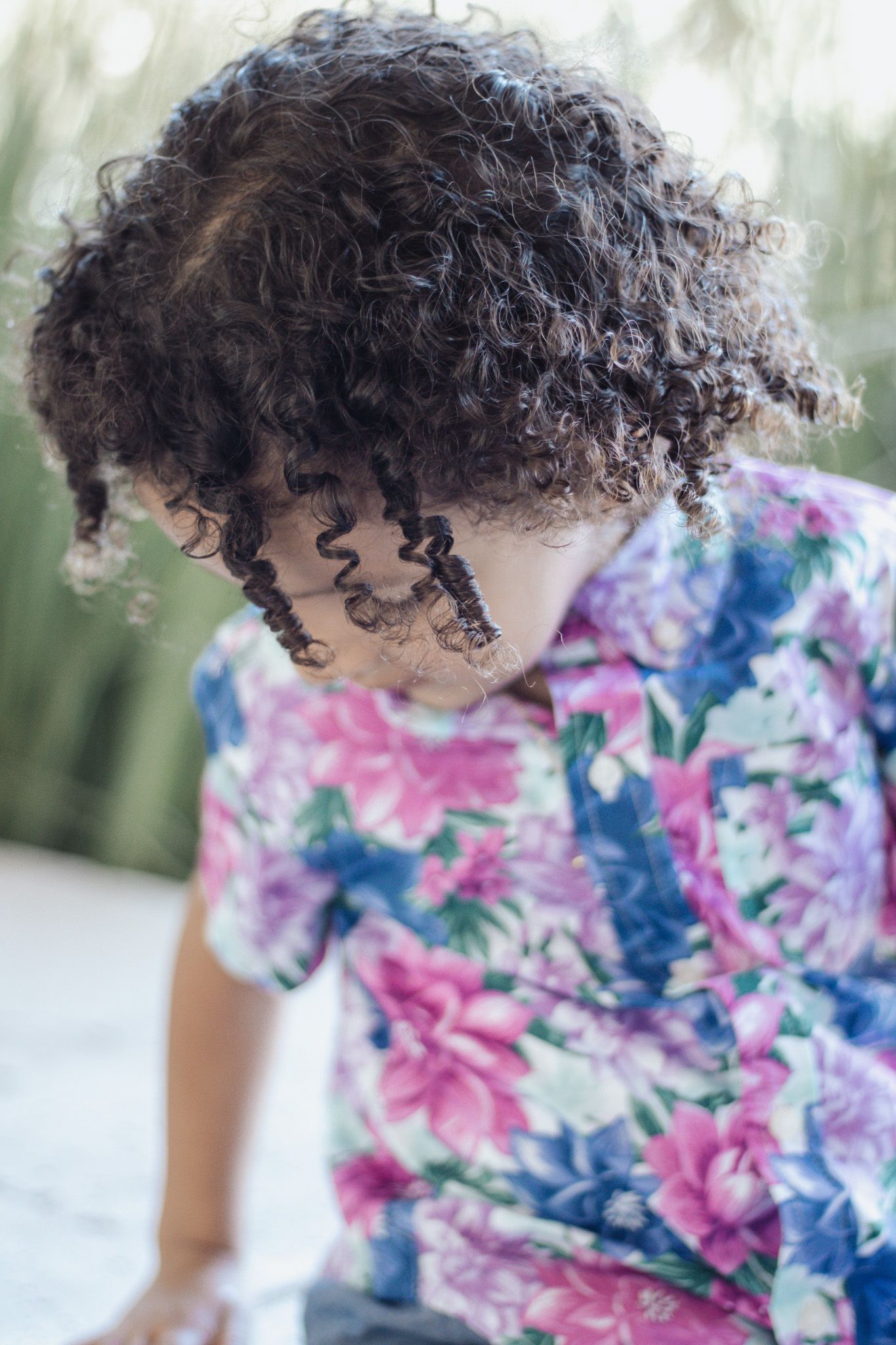 A floral dress with pink and blue watercolor patterns shown in a close-up detail shot.