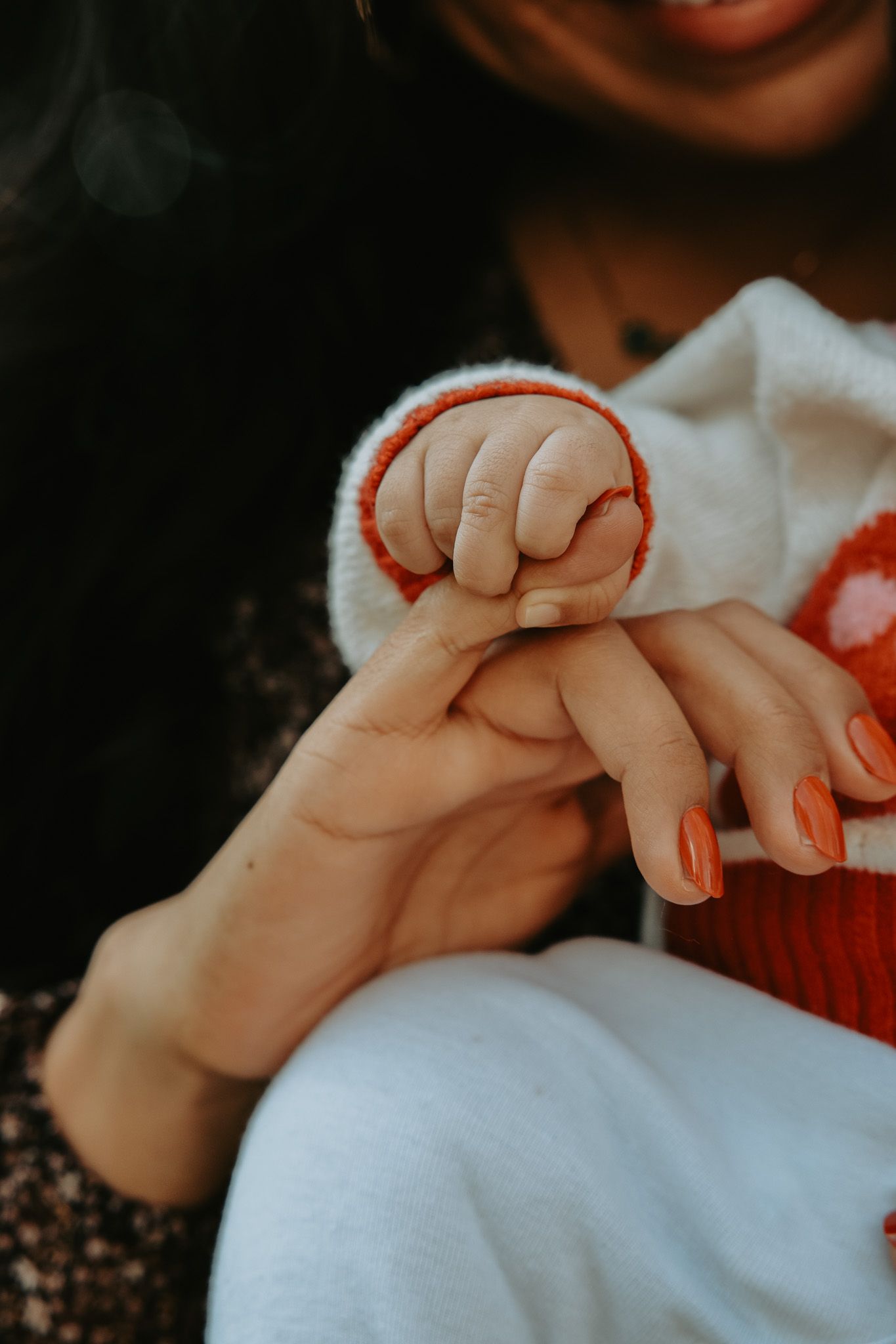 Close-up series of baby hands grasping and holding onto adult fingers against light and dark backgrounds.
