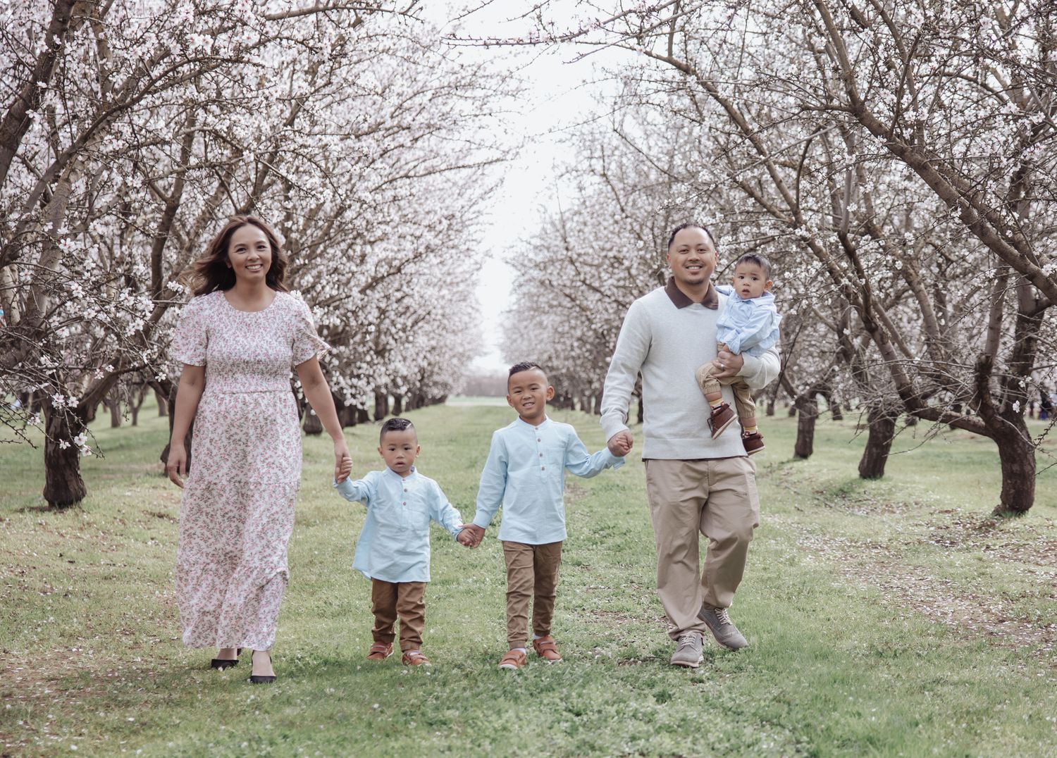 Natural‑light family portraits in Modesto almond blossoms with soft, editorial styling