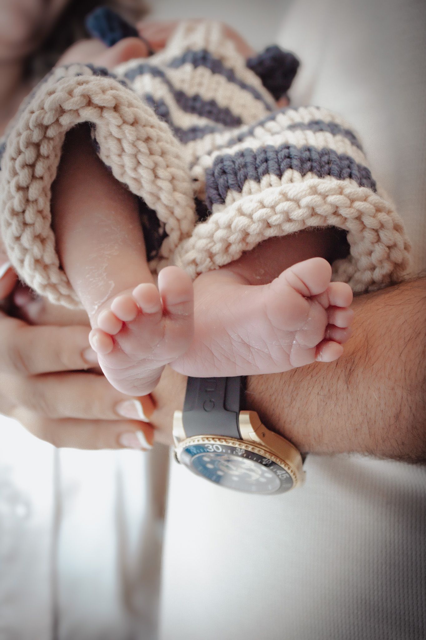 A series of photos showing tiny baby feet wearing knitted cream and gray booties.
