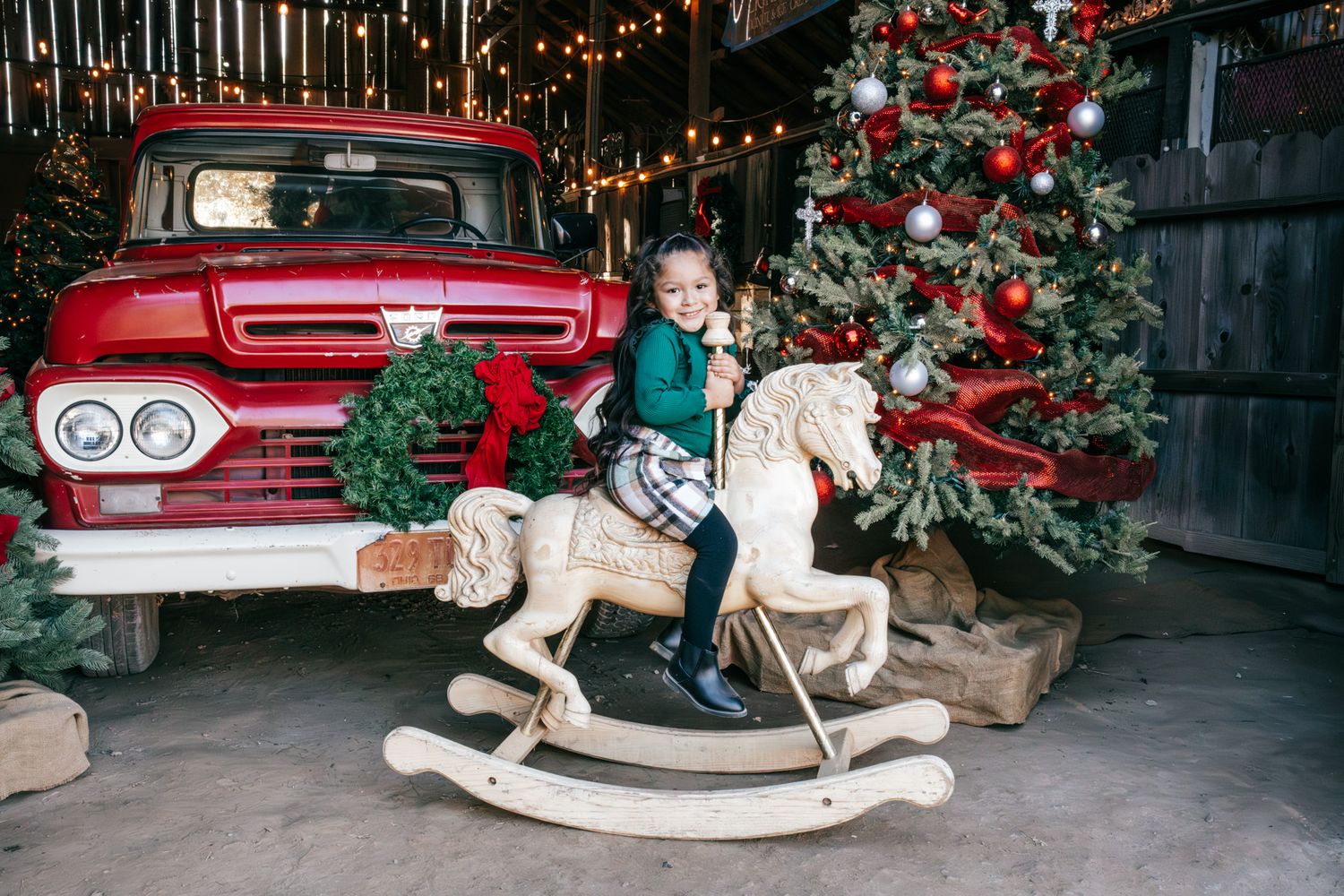 A collection of vintage Christmas scenes with red classic cars and holiday decorations displayed in a rustic setting.