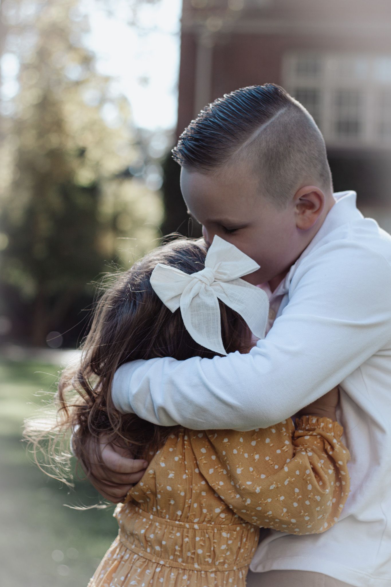 Kids hugging during fall minis at UOP in Stockton, CA, captured candidly with warm foliage on October 17th.