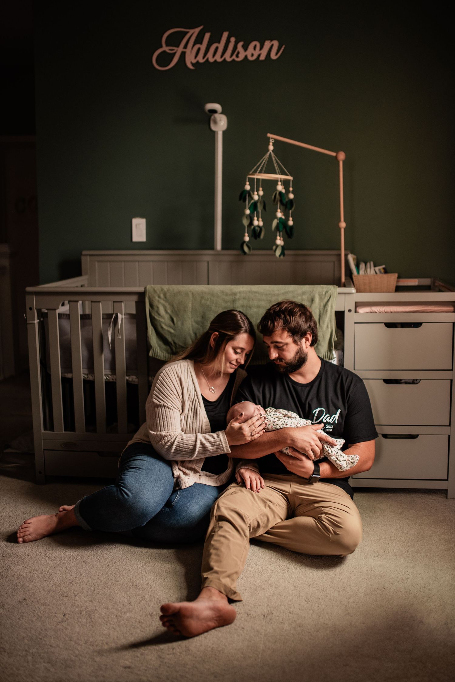 Mother and father hold newborn baby in soft sunlit nursery at home in Schuylkill County, PA photographed by R&J Photography