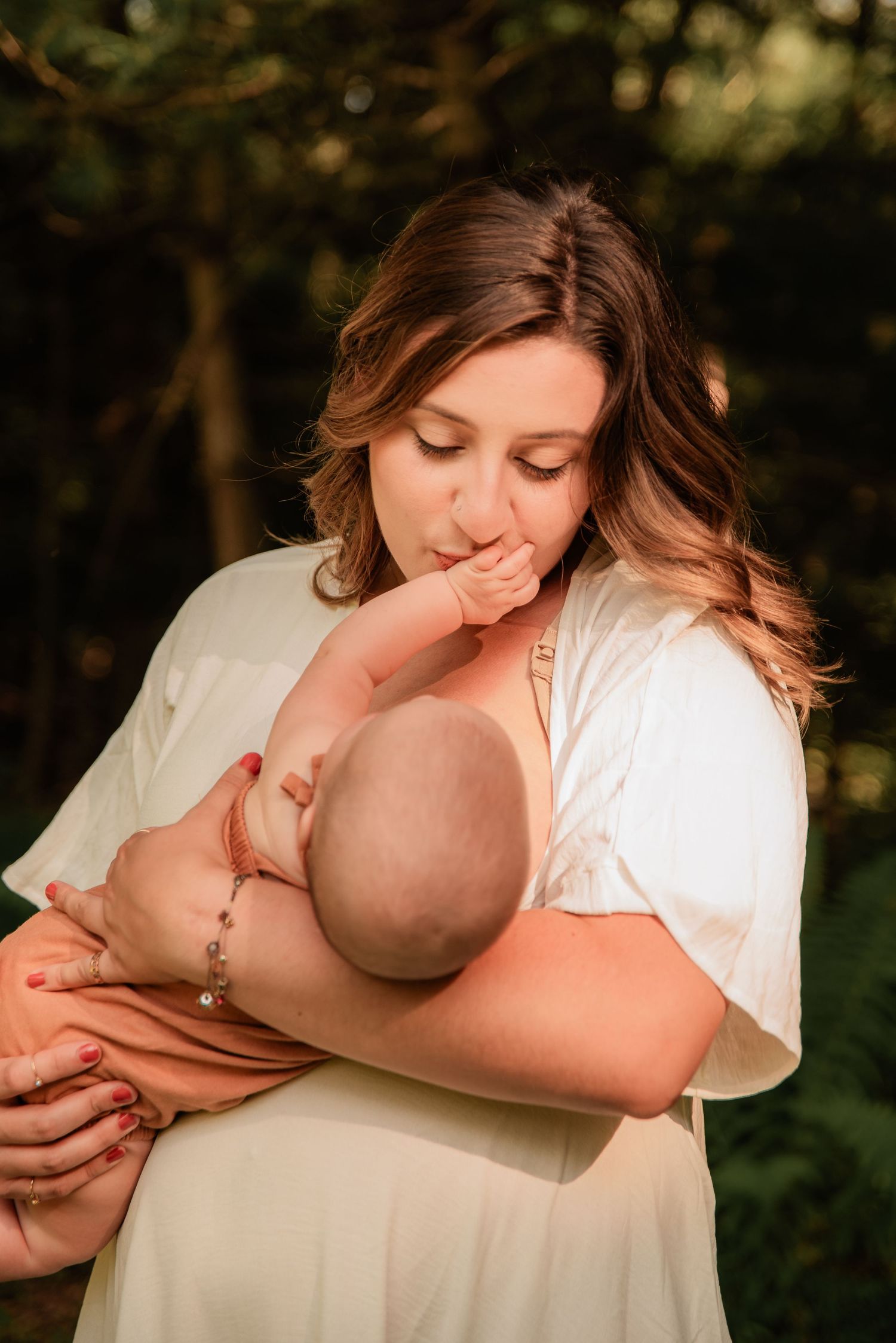Emotional lifestyle portrait of a mother cradling her nursing baby in a warm outdoor setting in Hometown, Schuylkill County, PA.