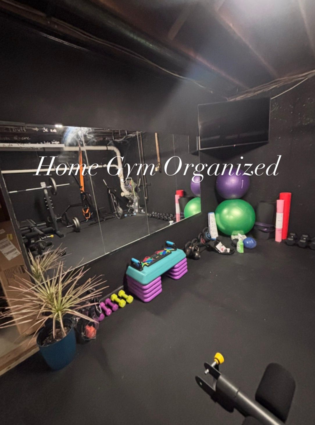 Organized home gym with exercise equipment, mirrors, weights, and fitness accessories neatly arranged.